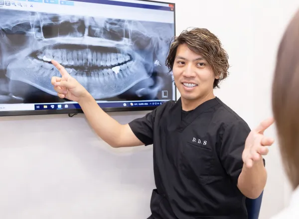 レントゲン画像を使って説明する歯科医師